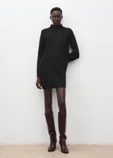 Vestido corto de punto en color negro, con cuello alto y manga larga. Presenta un diseño minimalista y ajustado.