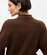 Suéter de punto color marrón chocolate, con cuello alto y mangas largas con puños ajustados. Presenta un diseño de corte corto y holgado.