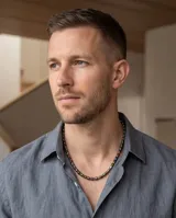 Collar masculino confeccionado con cuentas cilíndricas de acero y piedras naturales en tonos marrones y plateados.