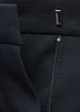 Pantalón de vestir azul marino de tiro medio, con bolsillos laterales, bolsillos de ribete traseros y diseño recto con botamanga con vuelta.