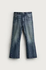 Jeans flare fit de denim de algodón en color azul, con lavado efecto desgastado, tiro medio y corte acampanado desde la rodilla. Cuenta con diseño de cinco bolsillos y cierre frontal con cremallera y botón.