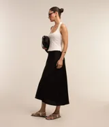 Pollera midi negra de corte evasé, confeccionada en tela satinada de poliéster.