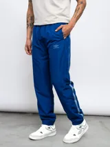 Pantalón deportivo negro de nylon con detalles en contraste blanco y logo de Umbro bordado en el lateral. Corte relajado.