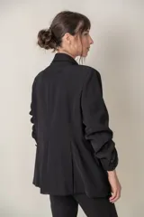 Blazer negro cruzado con solapas adornadas con strass y bolsillos delanteros con solapa.