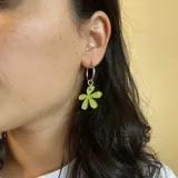 Aros colgantes plateados con dije de flor color verde lima.
