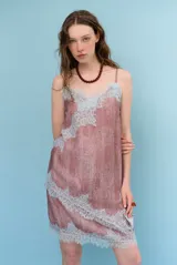 Falda tubo corta de color marrón con estampado de lunares blancos, detalle de encaje blanco en el dobladillo y tiras decorativas.