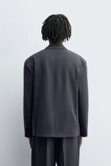 Blazer de corte relajado confeccionada en tejido con lana. Presenta cuello con solapas de muesca, manga larga con puños abotonados, bolsillos de vivo en la cadera y bolsillo interior. Cierre frontal de doble botonadura.