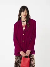 Blazer de terciopelo color fucsia con solapas y botones dorados.