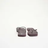 Chanclas de dedo color bordó con suela plana y tiras finas texturizadas.