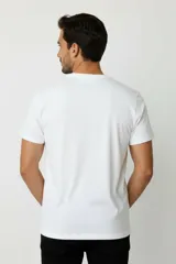 Remera de manga corta y cuello redondo, color blanco, de corte holgado, con estampa pequeña de un velero en el pecho.
