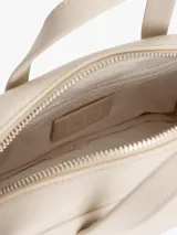 Cartera de mano tipo bowling de Tommy Jeans, color beige, con doble asa superior y correa ajustable extraíble. Presenta un diseño estructurado con cierre superior y logo metálico de la marca en la parte frontal.
