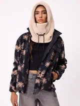 Pasamontañas de tejido tipo corderito sintético en color negro, con diseño de capucha integrada y cordones ajustables en la parte frontal.