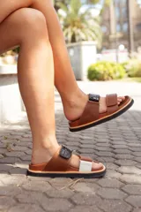 Sandalias de cuero color marrón con dos tiras ajustables, una de cuero liso y otra con textura de cocodrilo en color negro.