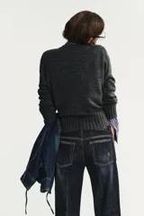 Jersey de punto con cuello redondo y manga larga, con acabados en rib ancho a tono y bajo asimétrico.