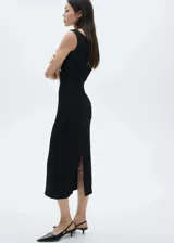 Vestido midi entallado de color negro, confeccionado en tejido con textura. Presenta cuello barco, diseño sin mangas y abertura posterior en el bajo.