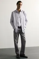 Jeans regular fit confeccionados en denim de algodón celeste con efecto lavado, de cinco bolsillos y cierre frontal con cremallera y botón.