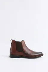 Botas tipo Chelsea de cuero color marrón, con paneles laterales elásticos y suela de goma oscura.