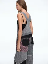 Mono de jean con diseño patchwork que combina diferentes texturas y estampados, incluyendo animal print y motivos geométricos. Presenta corte recto, bolsillos frontales y terminaciones deshilachadas.