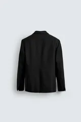Blazer de corte regular confeccionado en tejido de lana italiana. Presenta cuello con solapas de muesca, cierre frontal de un botón, bolsillos laterales con solapa y bolsillo de vivo en el pecho. Incluye aberturas en la espalda y forro interior.