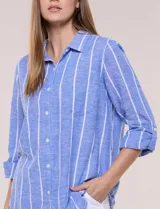 Camisa de lino de la marca Dash, color beige con rayas verticales blancas. Cuenta con cuello camisero, cierre frontal con botones, un bolsillo aplicado en el pecho y mangas largas con sistema de ajuste para arremangar.