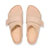 Sandalia Birkenstock modelo Kyoto de diseño minimalista, color beige, con una banda ancha ajustable mediante cierre de velcro, plantilla anatómica de corcho y suela de goma negra.
