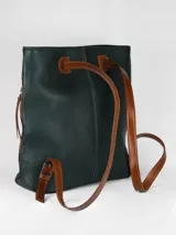 Mochila de cuero graneado color verde oscuro, con detalles en cuero color suela. Cuenta con manija superior, cierre lateral y costuras decorativas verticales.
