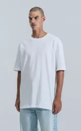 Remerón de algodón premium, color blanco liso, con corte extra oversize, hombros caídos y cuello redondo.