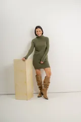 Vestido corto verde de tejido acanalado, con cuello alto volcado y mangas largas.