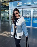 Campera de estilo híbrido que combina tejido de punto trenzado en color blanco con paneles de denim azul. Presenta cierre frontal con botones, bolsillos delanteros de denim y detalles de rayas negras en los bordes.