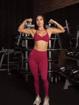 Set deportivo sin costuras color fucsia compuesto por un top bra con escote halter y espalda descubierta, y una calza legging con control de abdomen y realce de glúteos.