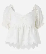 Blusa peplum color blanco, confeccionada en algodón, con escote corazón, mangas abullonadas cortas y bordado floral.