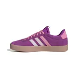 Championes Adidas modelo VL Court 3.0, de diseño clásico con parte superior de gamuza en color violeta. Presenta las icónicas tres tiras laterales en degradado de rosa a blanco, suela de caucho en tono marrón claro y detalles en dorado.