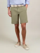 Bermuda de hombre de corte regular fit, color verde militar, confeccionada en mezcla de algodón y elastano. Cuenta con bolsillos laterales y bolsillos traseros.