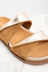 Sandalias bajas con base dorada y dos tiras anchas cruzadas en cuero color marrón y dorado.