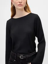 Remera de manga larga con cuello bote, confeccionada en tela fluida de color negro, con corte recto y acabado liso.
