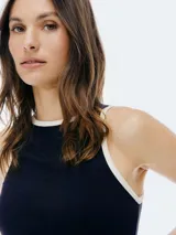 Musculosa de tela acanalada negra con ribetes blancos en el cuello y sisas, de corte ajustado.