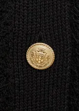 Chaleco negro de tejido de punto con textura, cuello redondo, sin mangas y cierre frontal con botones dorados.