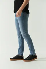 Jean clásico de hombre, corte regular, con logo bordado, grifa de cuero y pasacinto.