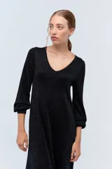 Vestido largo negro con sutiles detalles de lurex azul, escote en V y mangas largas.