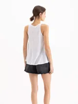 Musculosa blanca de lino y viscosa, con escote redondo y espalda cerrada, de corte fluido y holgado.