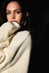 Sweater oversized color crema, tejido de punto con escote en V, roturas en ruedo y puños, y badana de PU en la espalda.