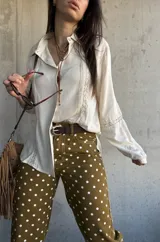 Camisa de manga larga color marfil con detalles de encaje y botones frontales.