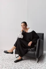Sweater de punto liviano negro, con escote bote y mangas amplias de largo tres cuartos que aportan una silueta relajada y fluida.
