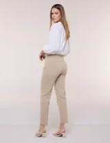 Pantalón de gabardina elastizada color beige, de tiro medio y calce slim. Cuenta con diseño pull-on sin cierres ni botones, cintura ancha, bolsillos delanteros simulados y bolsillos traseros ojal.