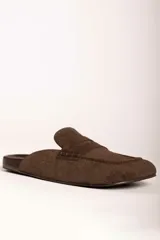 Zueco tipo mocasín destalonado en color verde oliva, con textura grabada efecto cocodrilo y acabado en gamuza.