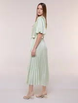 Vestido maxi de satén color rosado, con escote en V cruzado, mangas cortas amplias, cintura elastizada con lazo de ajuste y falda plisada con forro interno.