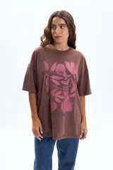 Remera oversize de manga corta color marrón con efecto desgastado y estampado frontal en rosa de hojas y la palabra "BROOKLYN".