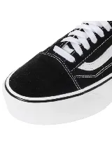 Championes Vans modelo UA Old Skool Stackform, de color negro con la clásica franja lateral blanca y suela de plataforma alta en color blanco.