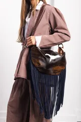 Cartera de cuero vacuno con estampado animal print, flecos largos de gamuza azul y asa con detalles de pasamanería.