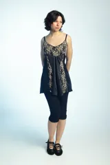 Musculosa de satén negro con inserciones de encaje beige con motivo floral en el escote y los laterales, tirantes finos y silueta acampanada.